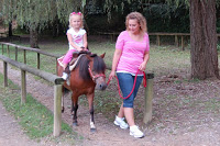 exotic petting zoo mom leading girl on pony