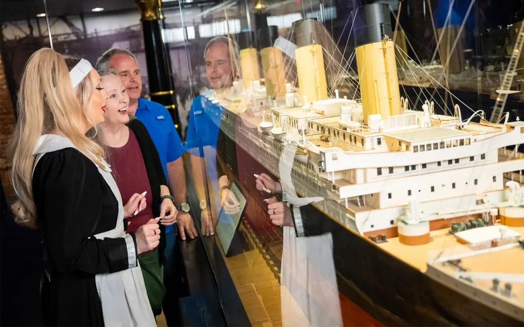Crew Member Talking With Couple at Captain Wheel at Titanic Museum Attraction