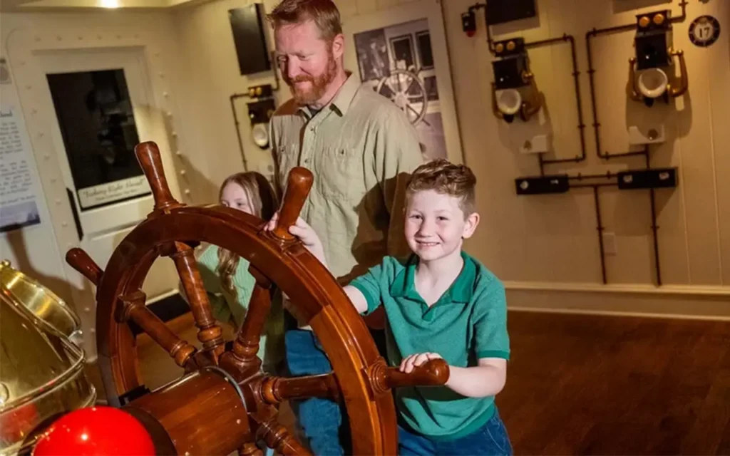 Father with Children at Captain Wheel at Titanic Museum Attraction