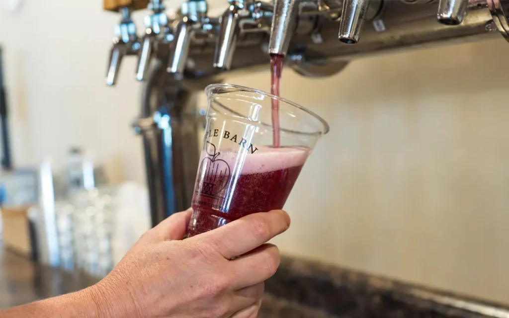 Pouring Glass of Hard Cider at Apple Barn Hard Cider Company